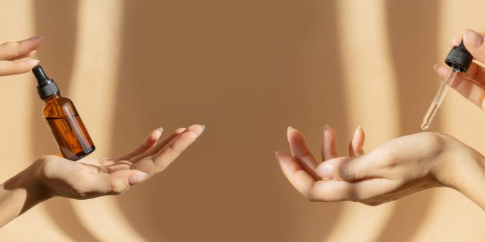 Two,Pairs,Of,Female,Hands,Hold,Bottle,Of,Amber,Glass